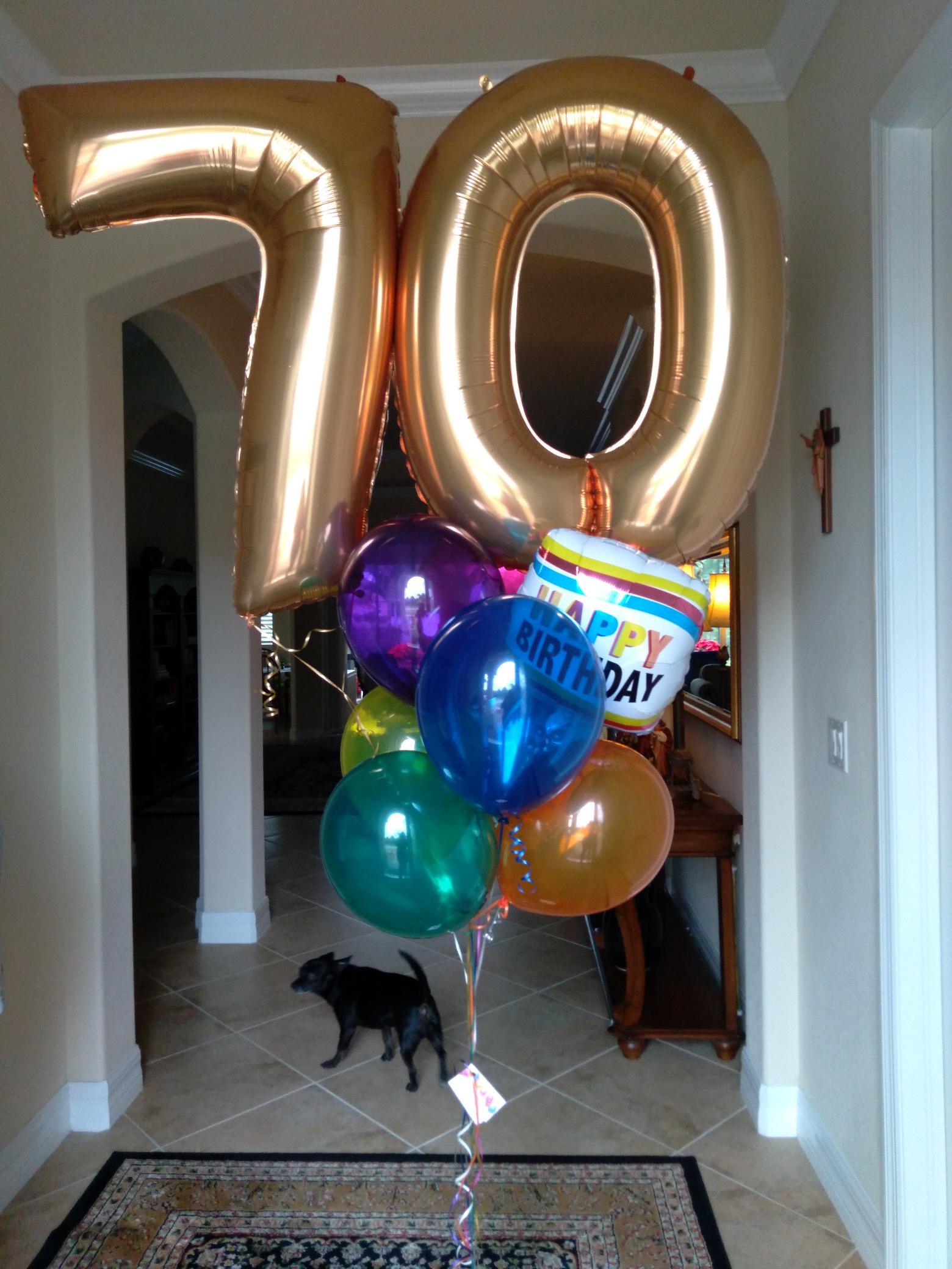 A bunch of balloons with the number 70 on them