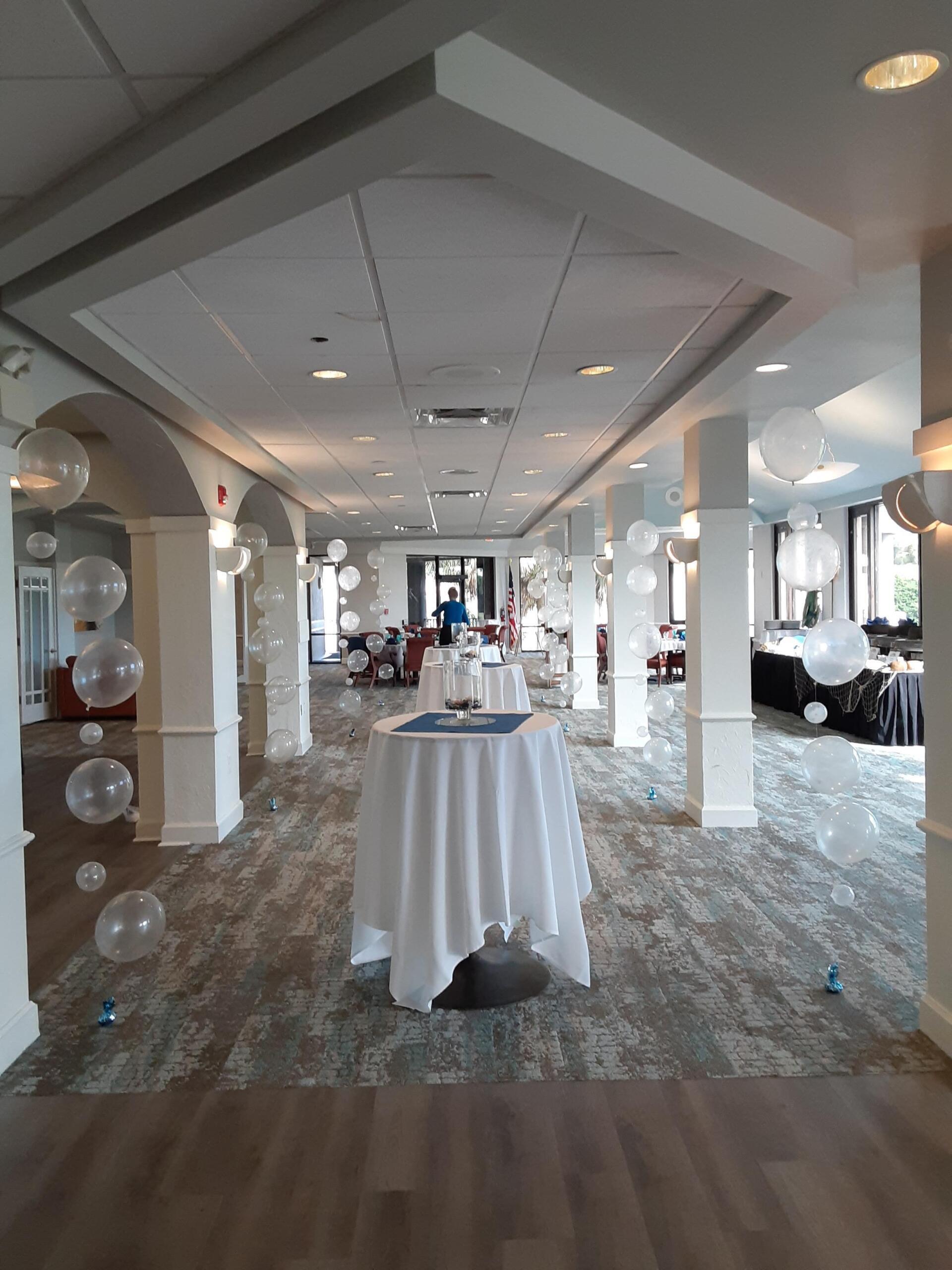 A large room with tables and balloons in it