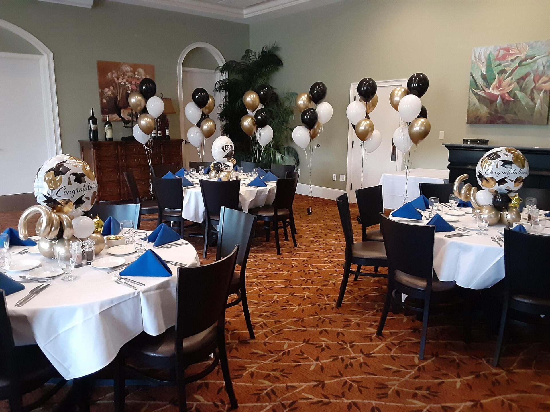 A room filled with tables and chairs decorated with balloons