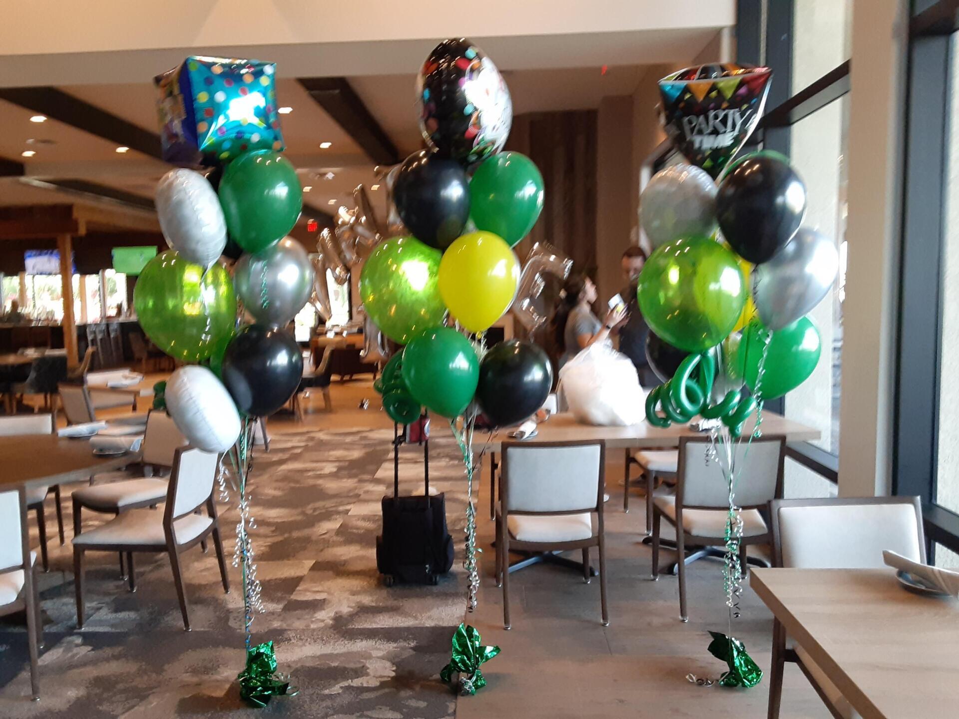 A bunch of balloons are sitting on a table in a room.