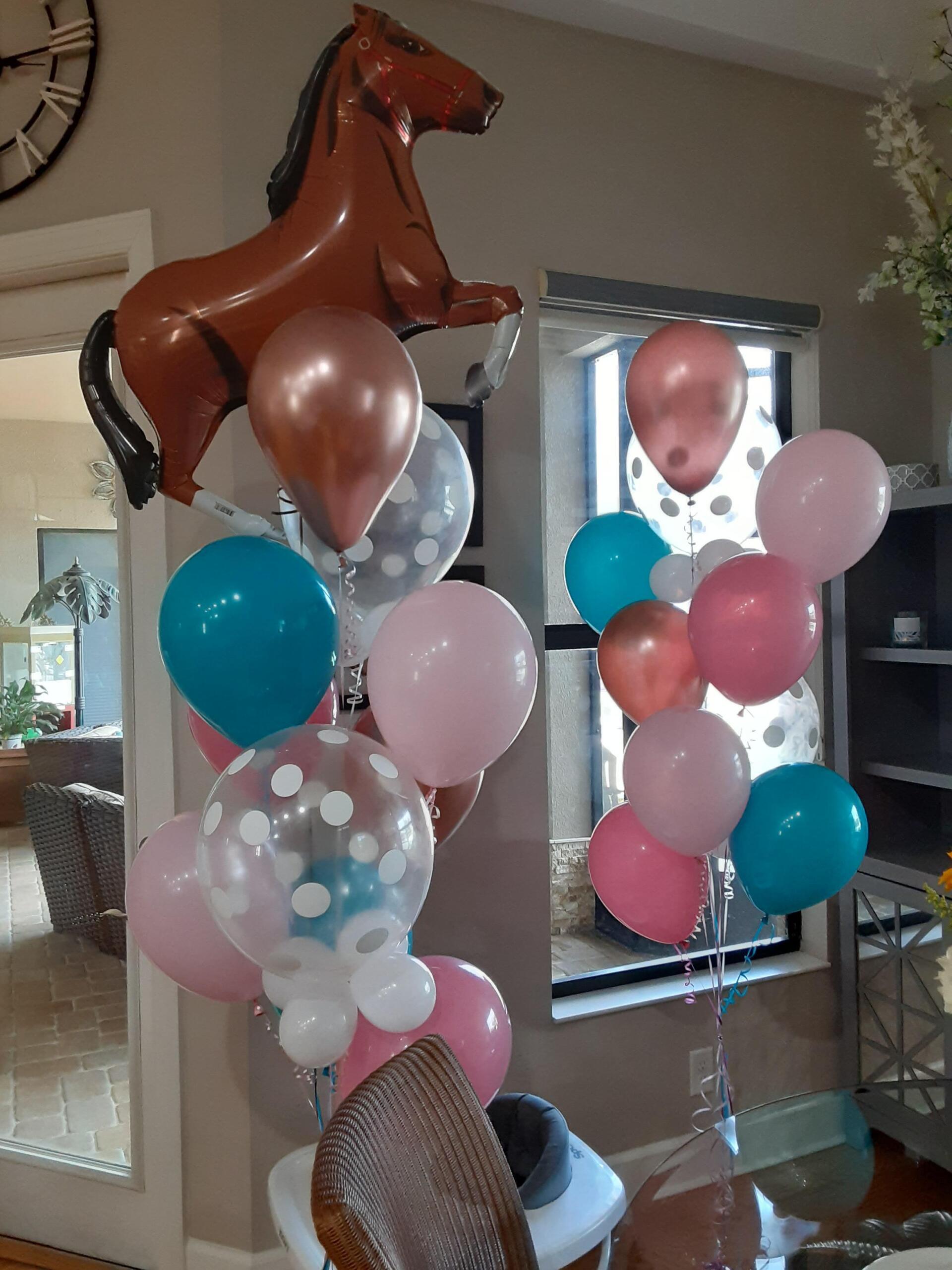 A bunch of balloons in a room with a horse balloon