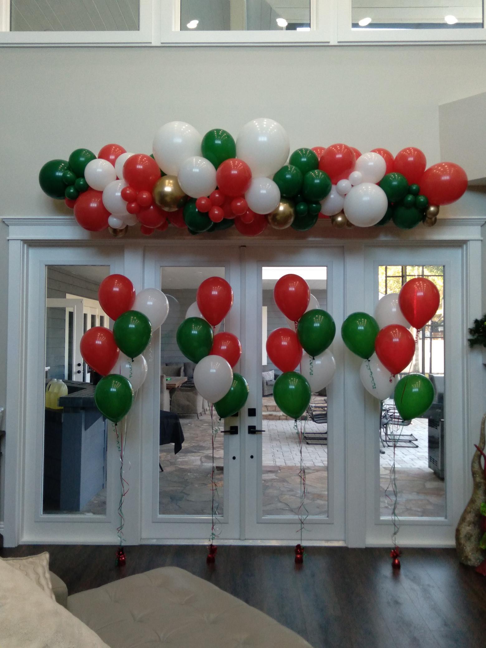 A bunch of red white and green balloons in a living room