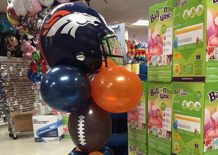 A bunch of balloons with a broncos helmet on top of them