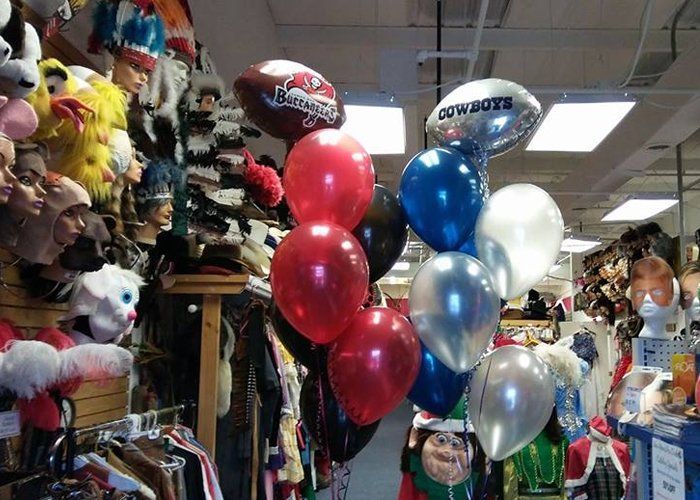 A bunch of balloons with one that says cowboys on it