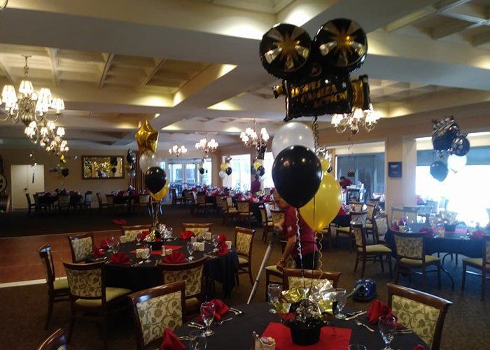 A large room filled with tables and chairs decorated for a birthday party.