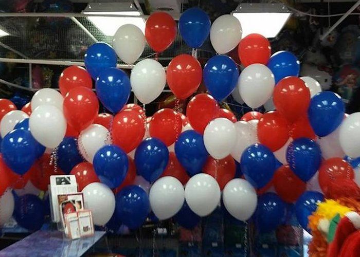 A bunch of red white and blue balloons in a room