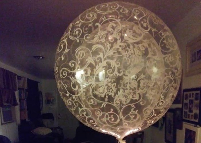A clear balloon with white swirls on it