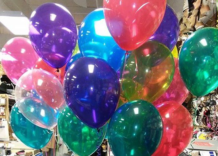 A bunch of colorful balloons are hanging from the ceiling