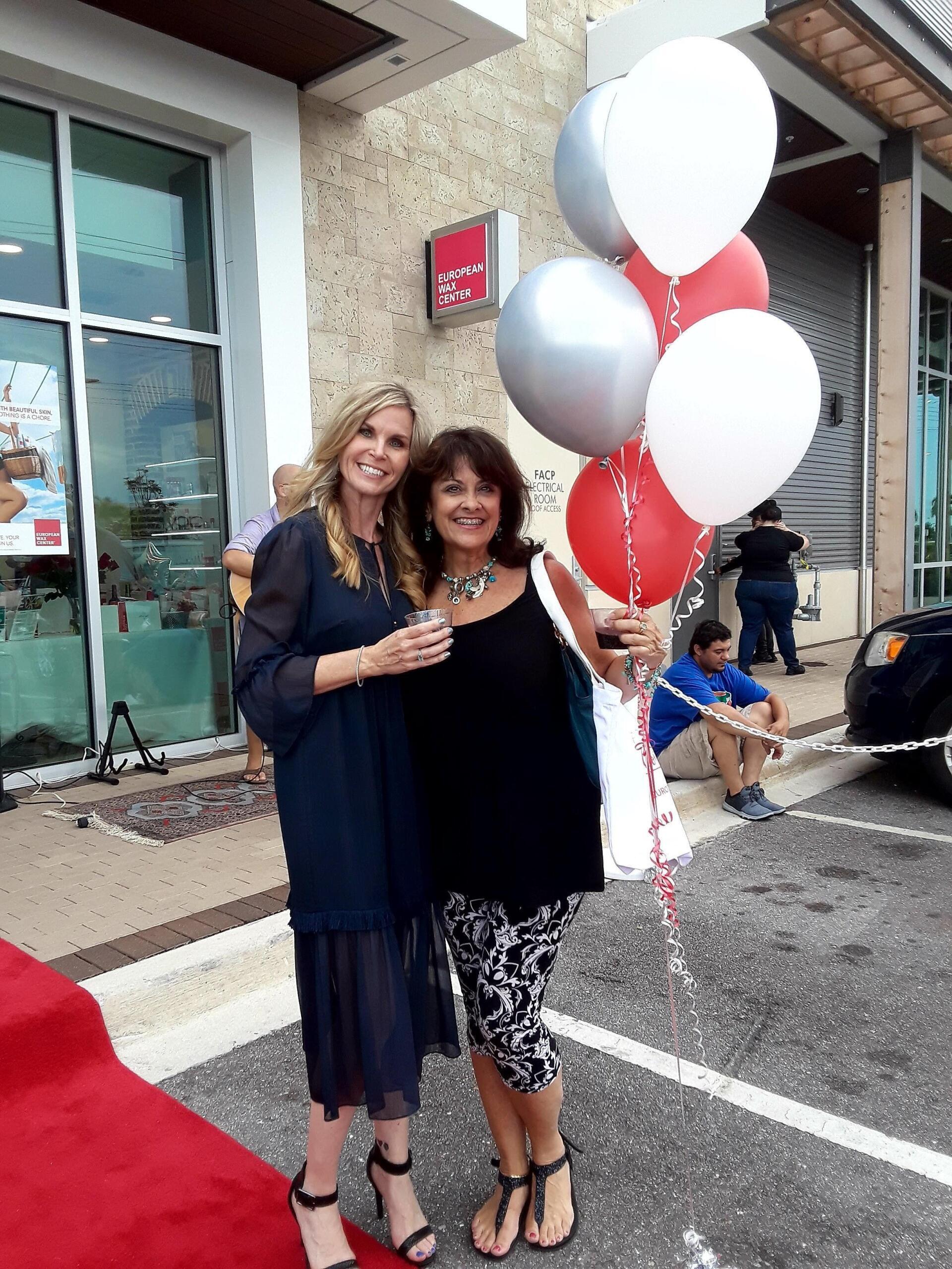 smiling women with silver gold and red balloons