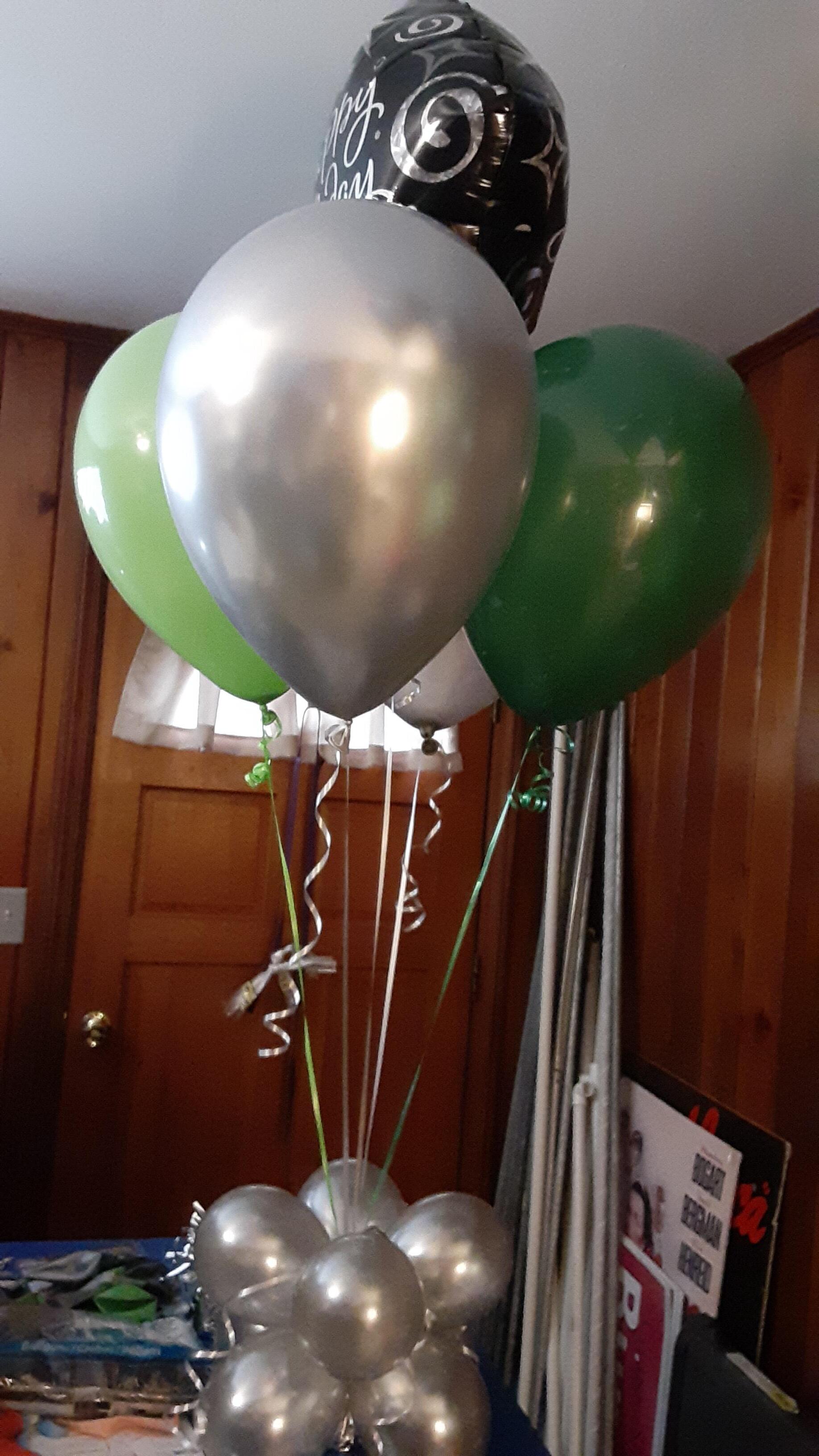 A bunch of balloons are sitting on a table in a room.