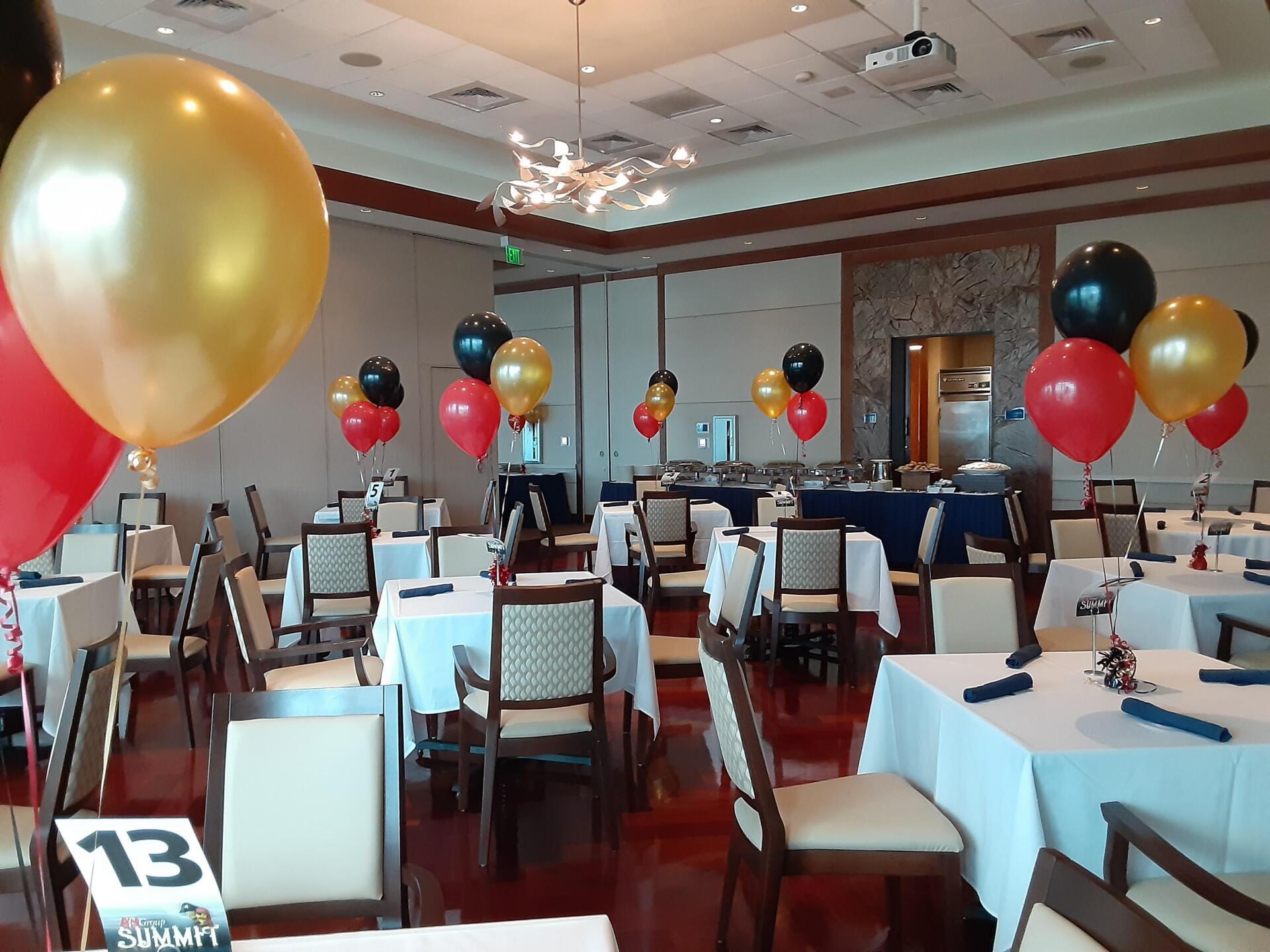 A room with tables and chairs and balloons and a table number 13