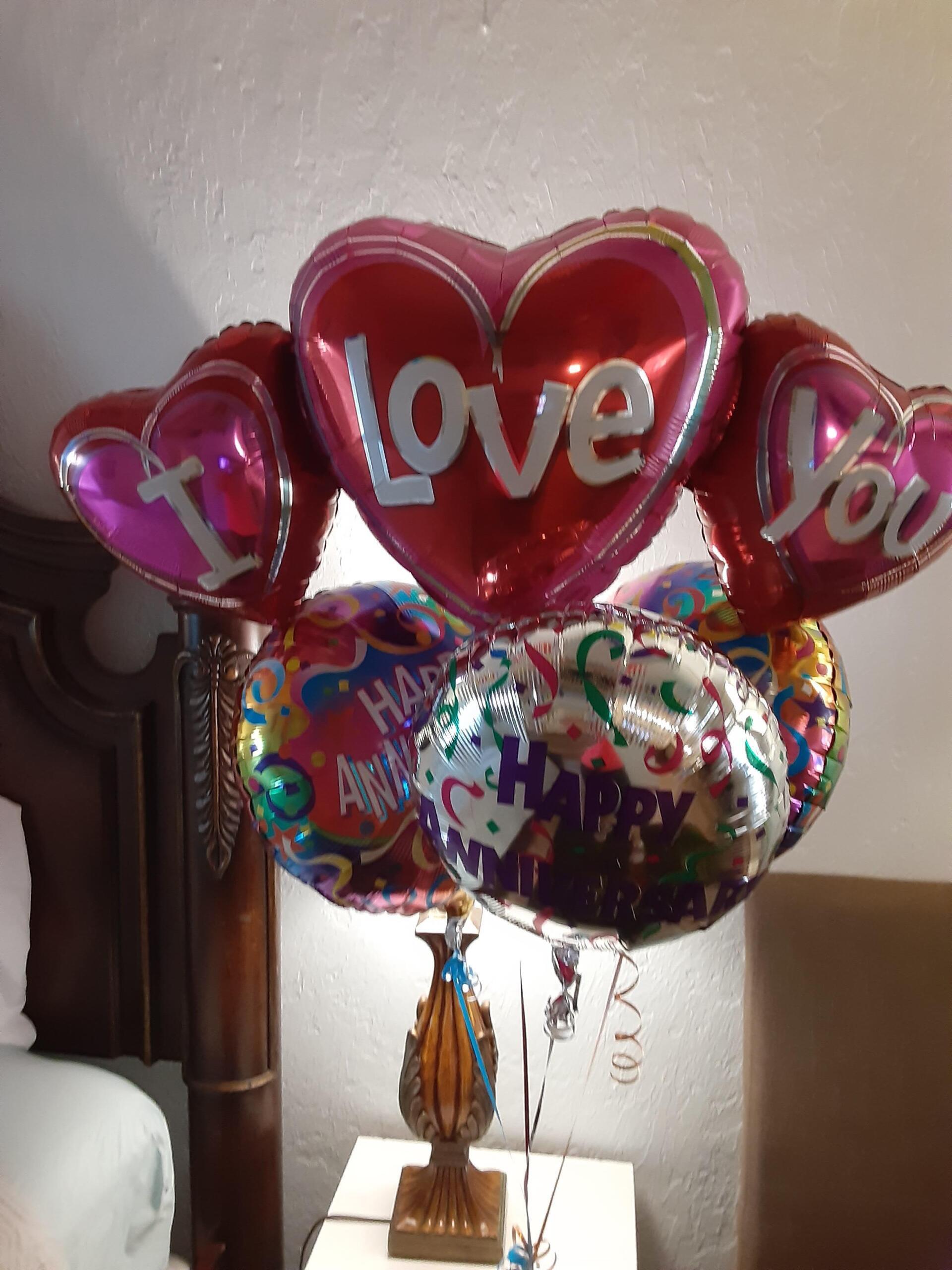 A bunch of heart shaped balloons that say i love you