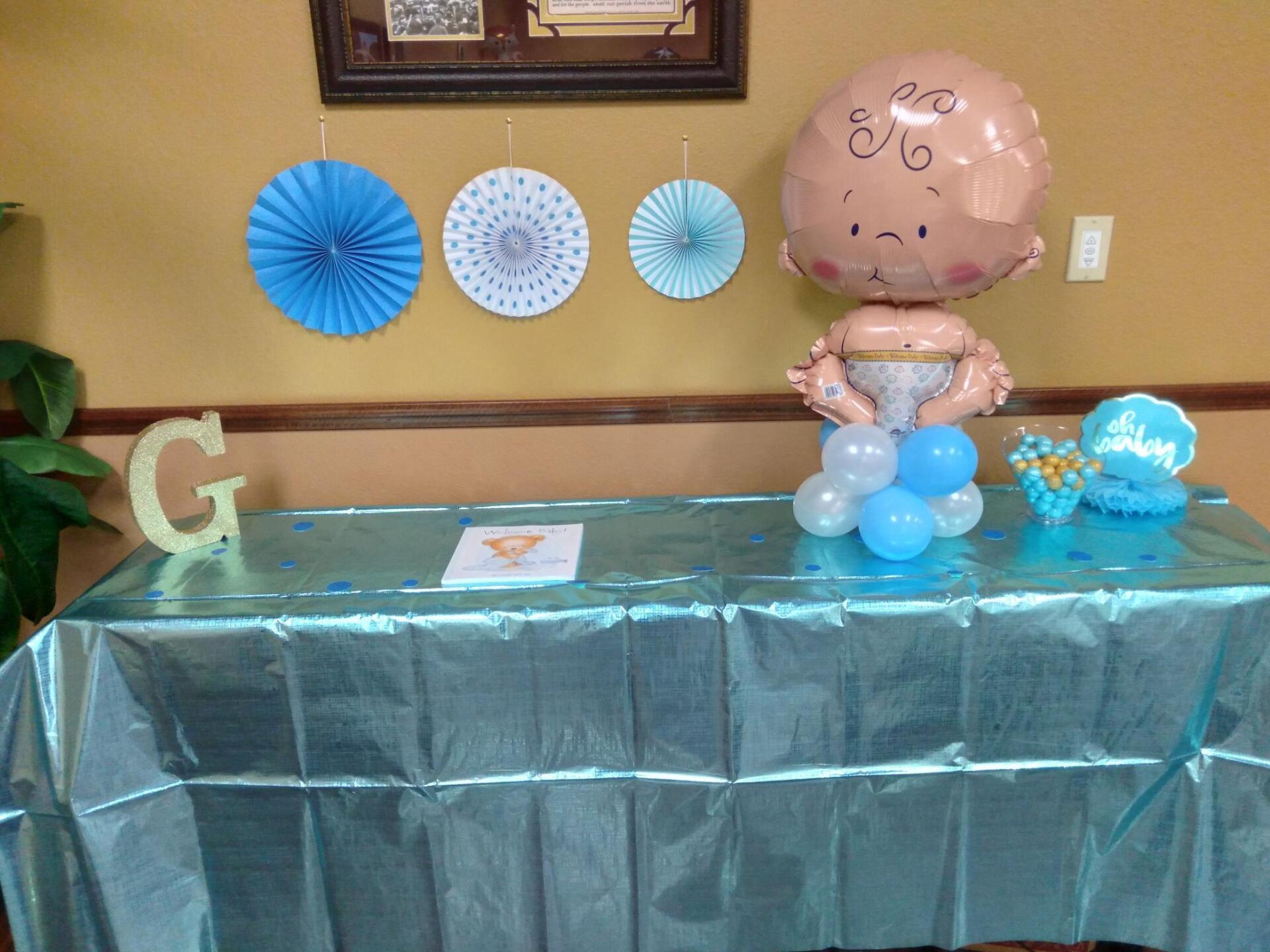 A baby shaped balloon is sitting on a table