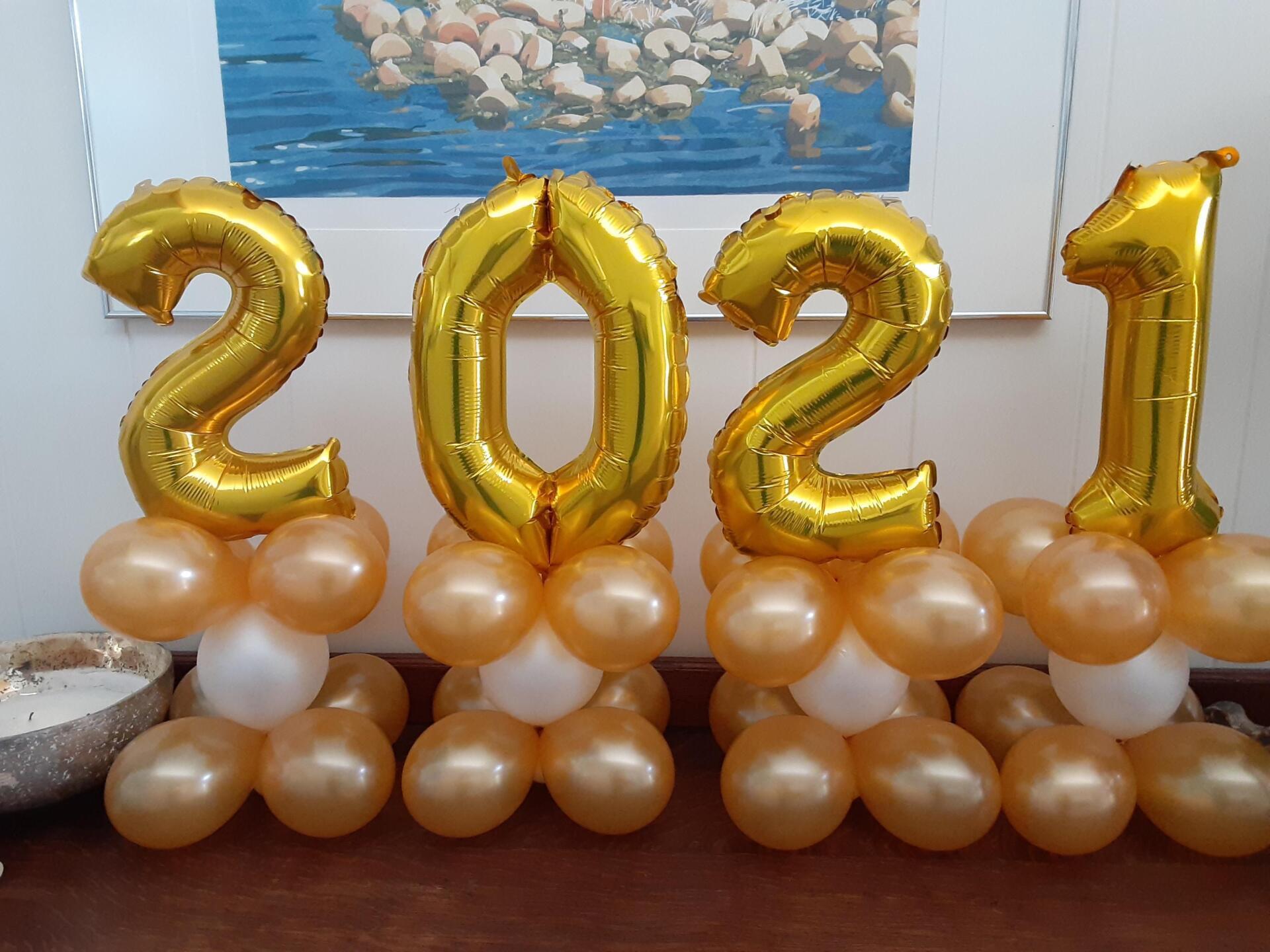 A bunch of gold balloons with the numbers 2021 on them