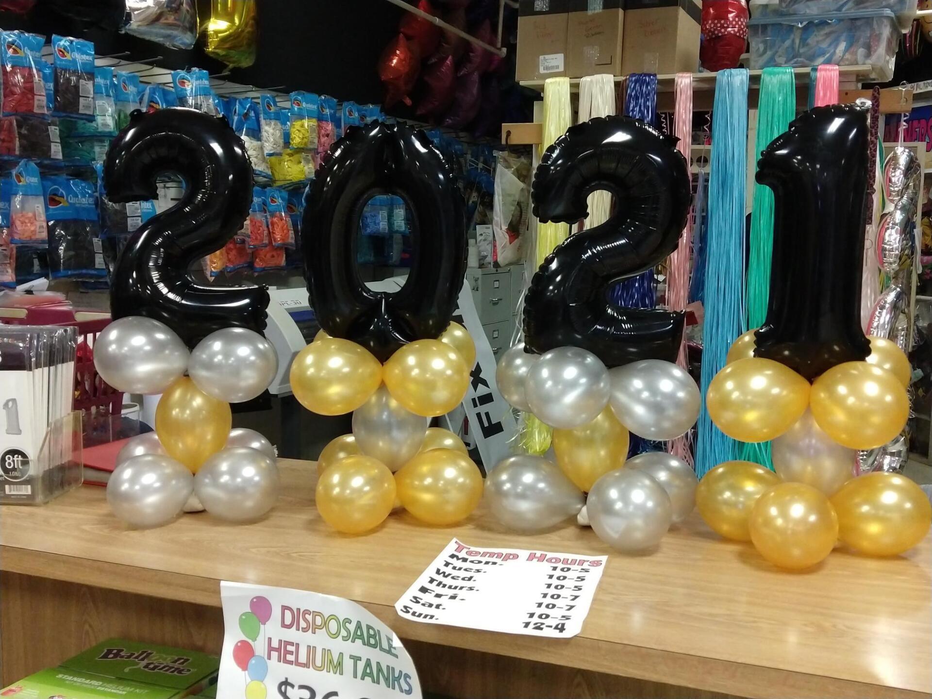 A table with balloons and a sign that says disposable helium tanks