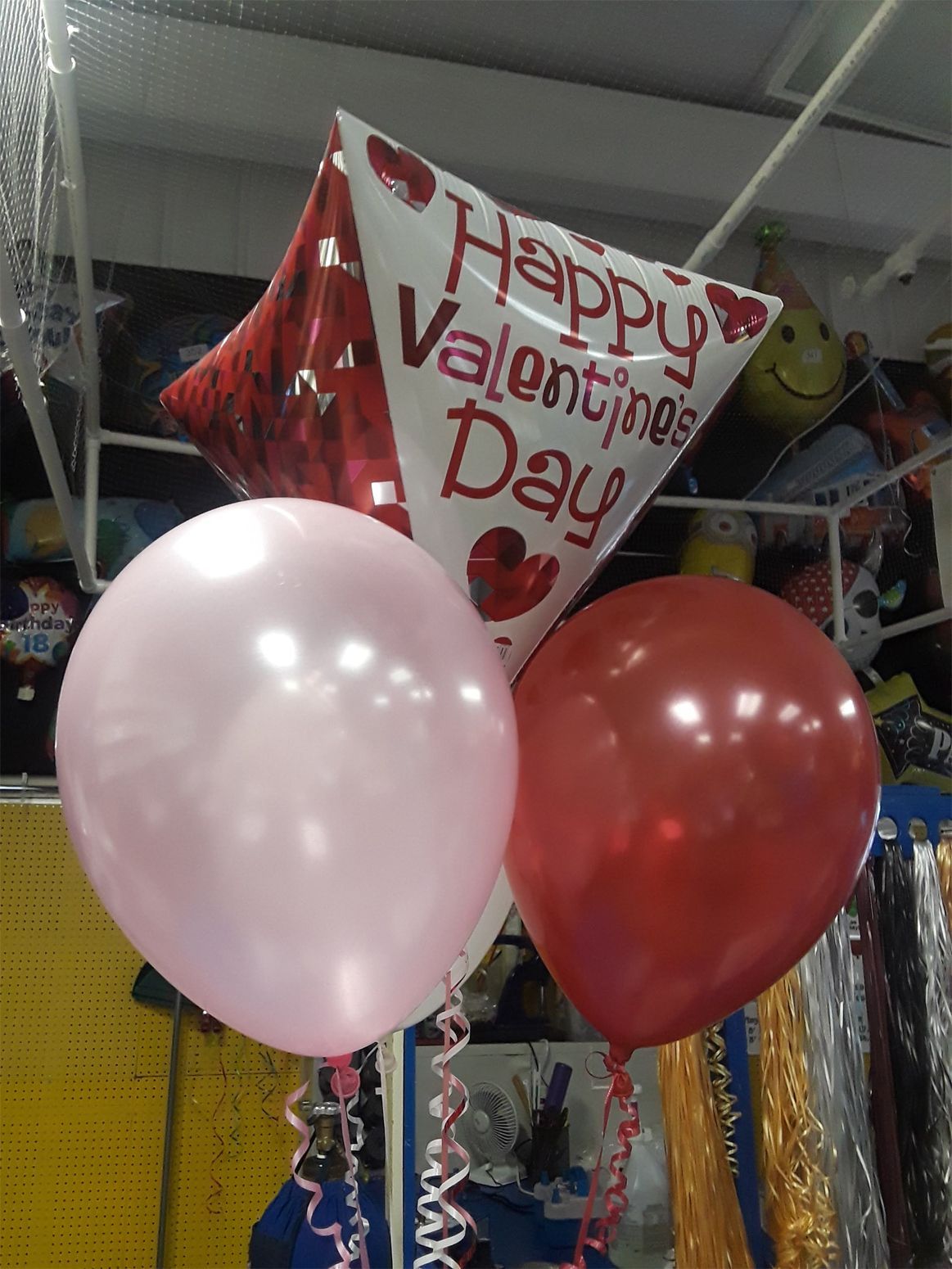 Valentine's Day balloon bouquet with a red and white diamond-shaped balloon and two round balloons: pink and red.