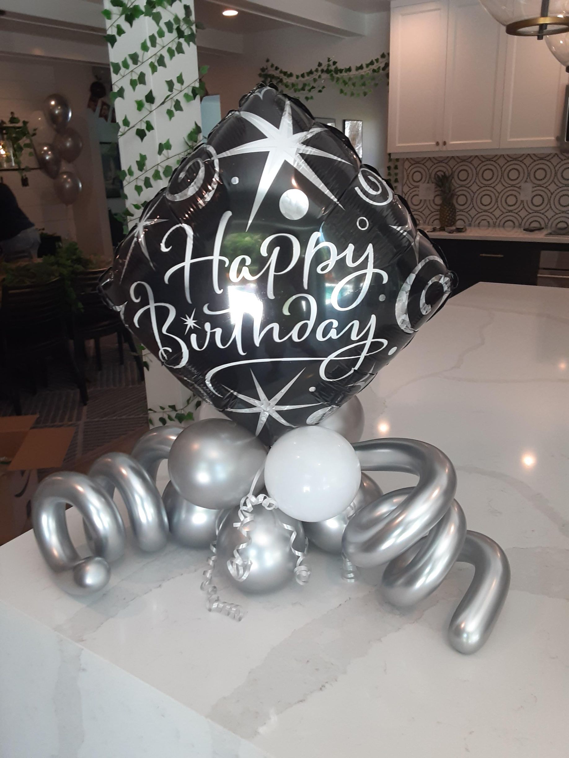 A happy birthday balloon is sitting on top of a table.