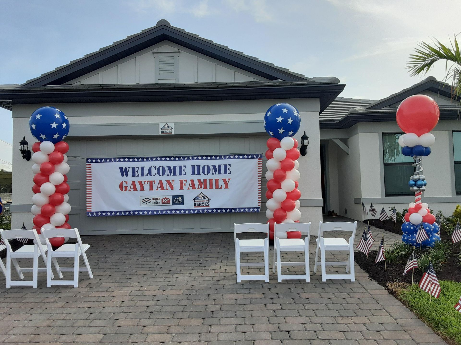 A house is decorated with balloons and a sign that says welcome home gaytan family