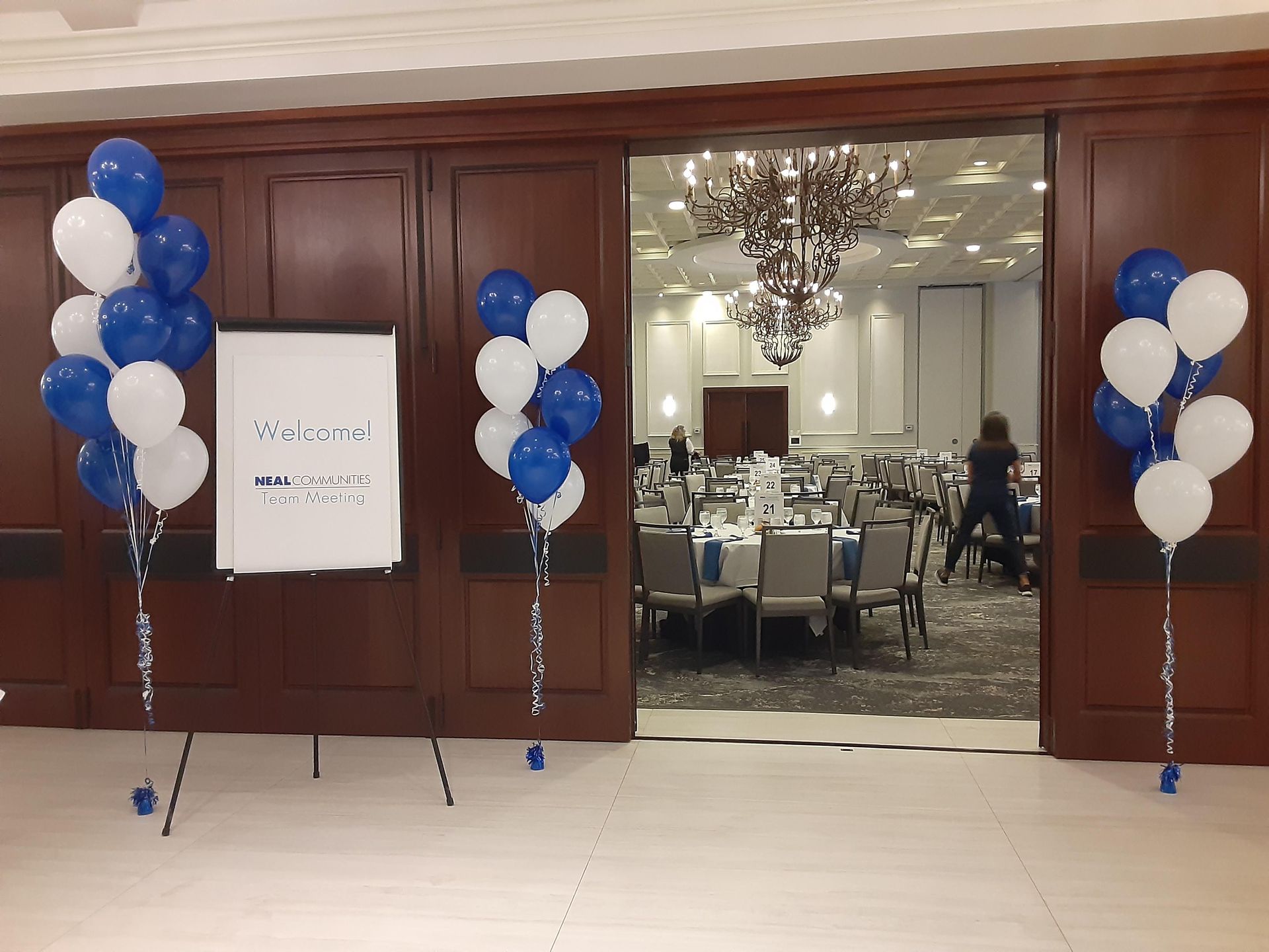 A room with blue and white balloons and a white board