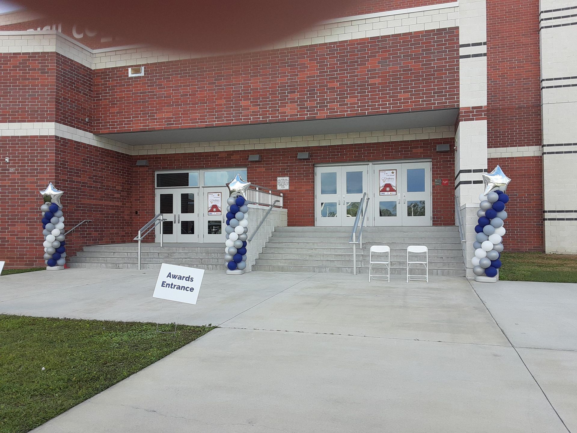 A brick building with blue and white balloons in front of it.