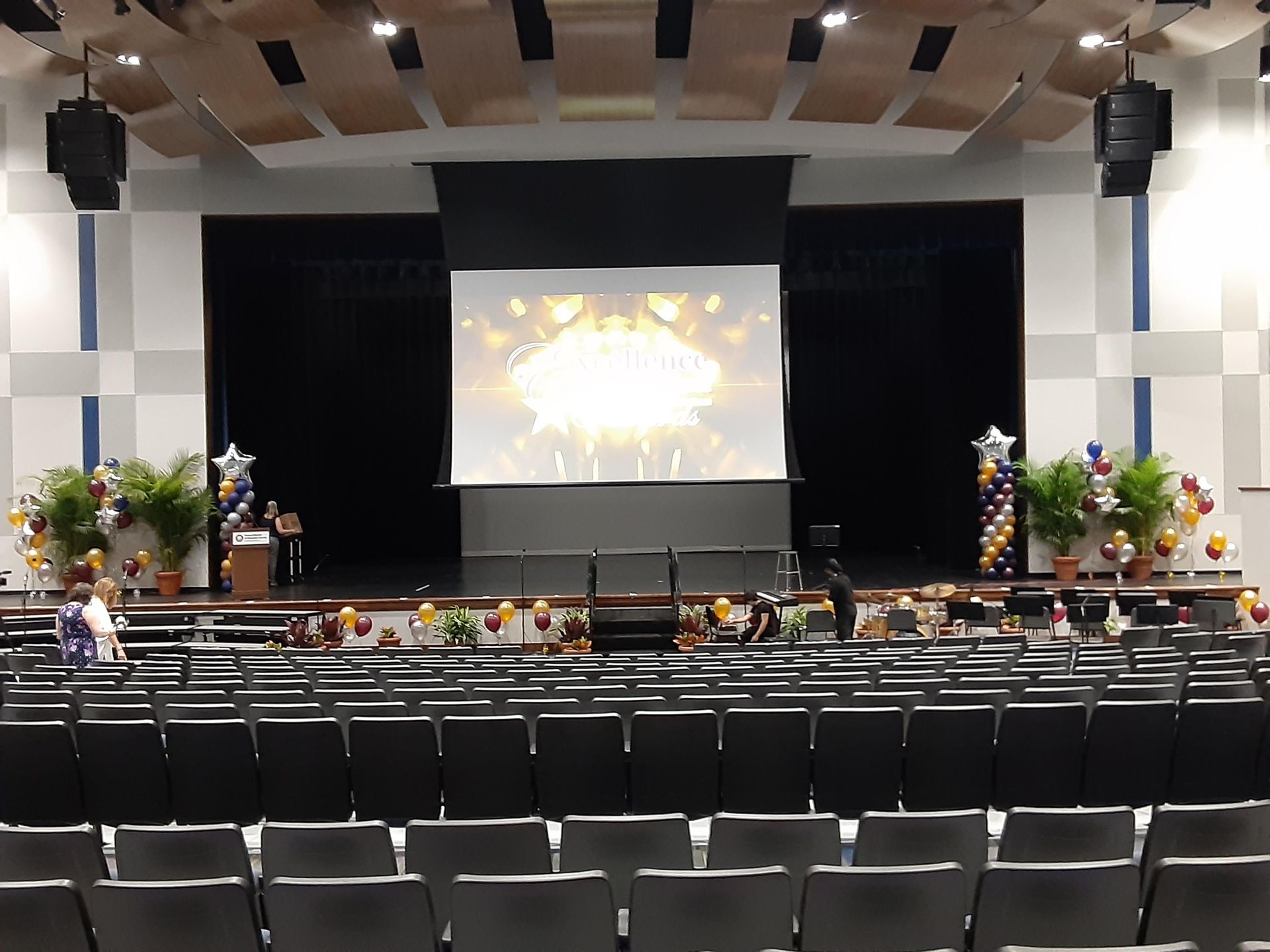 A large auditorium with a large screen on the stage