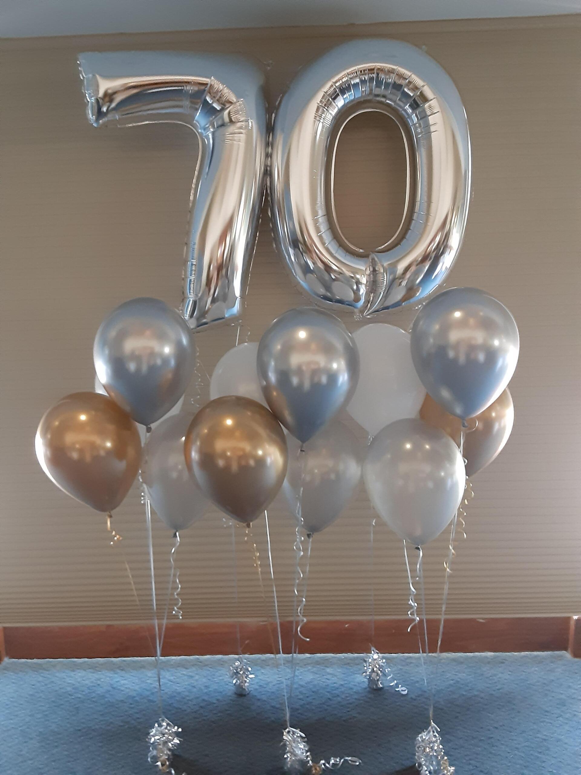 A bunch of balloons with the number 70 on them