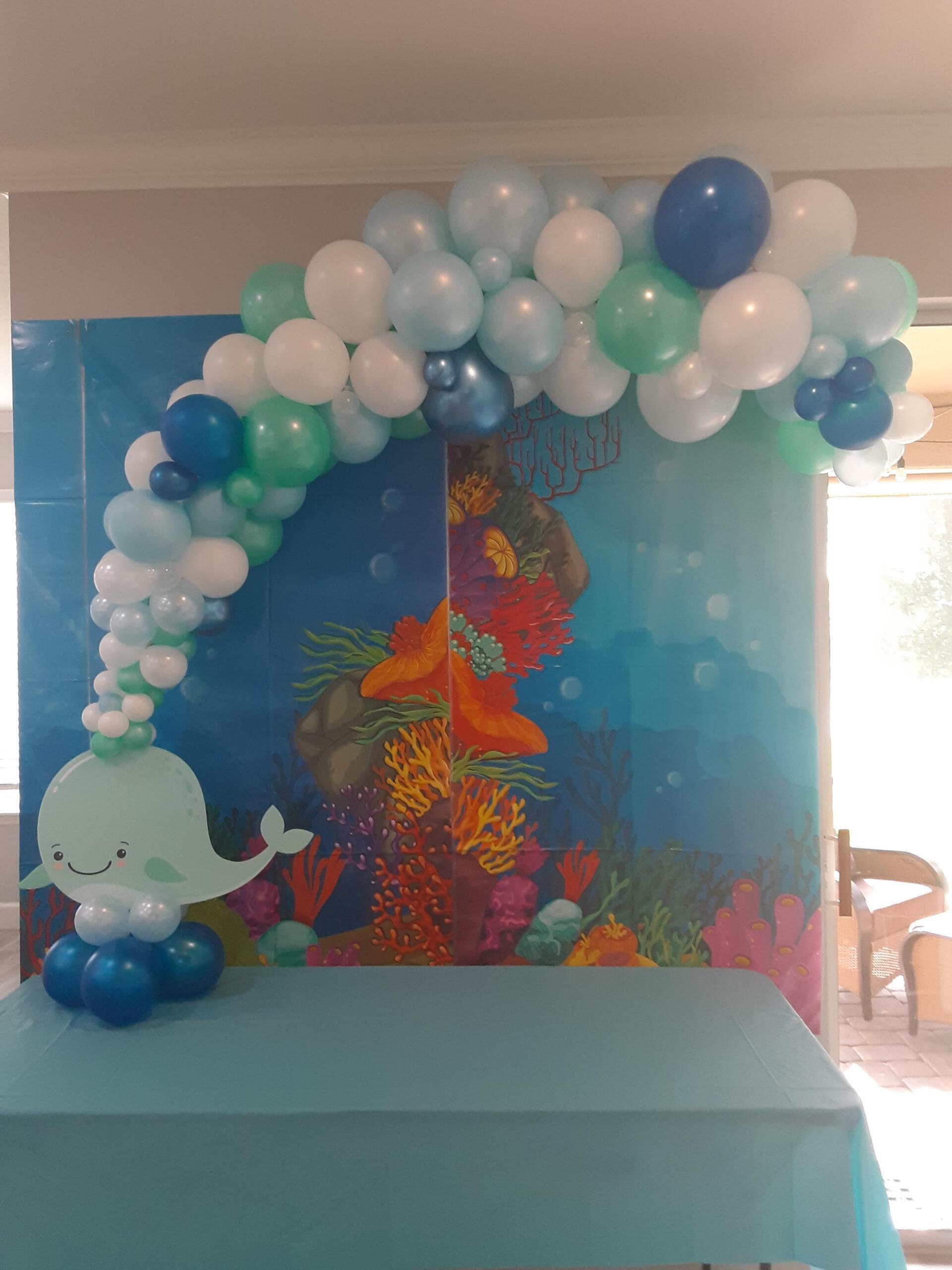 A table with a whale and balloons on it.