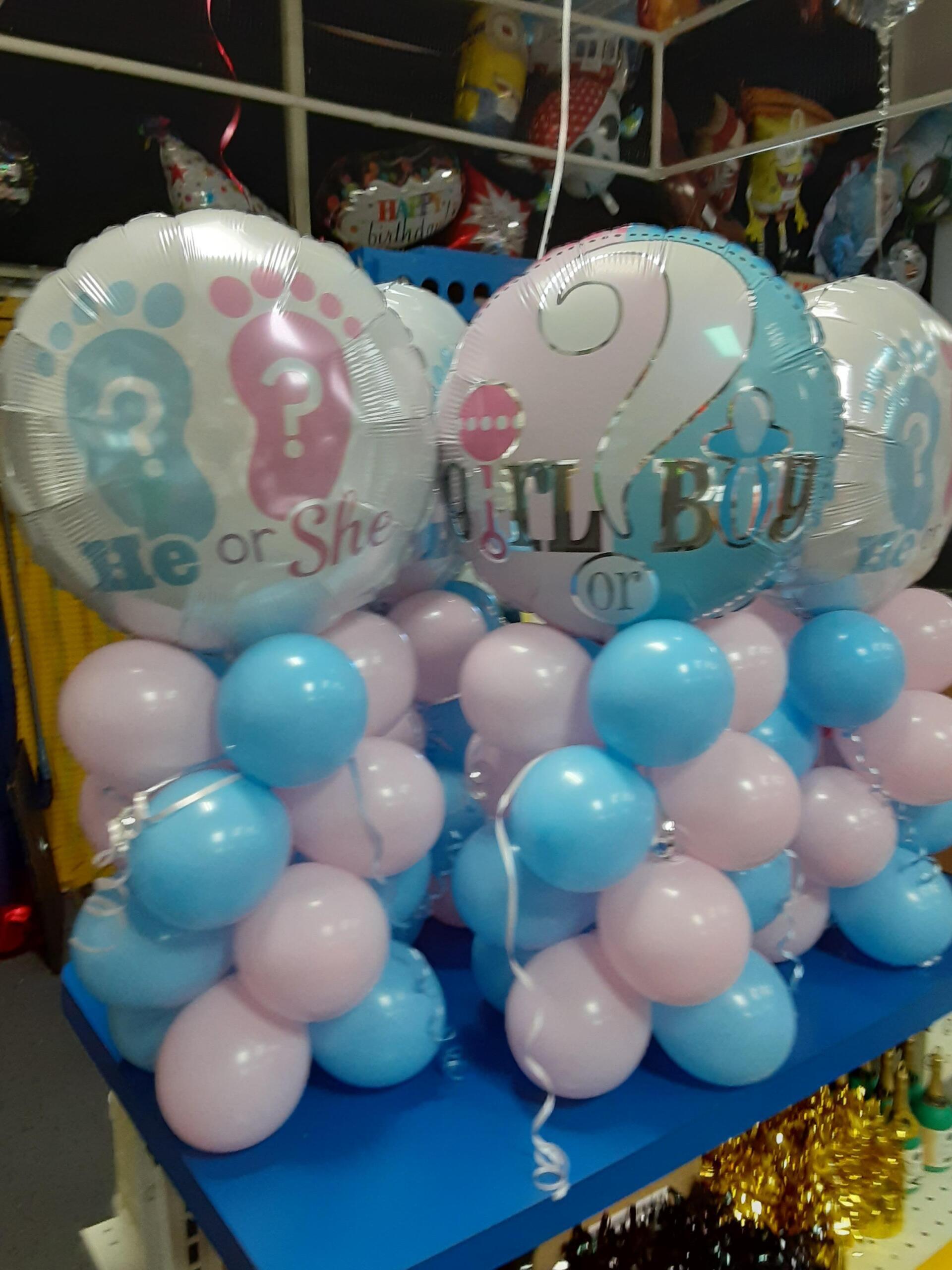 A bunch of balloons with one that says he or she