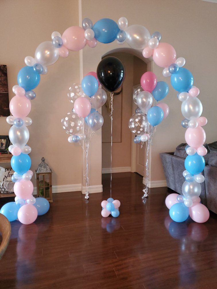 A room decorated with pink and blue balloons and a black balloon