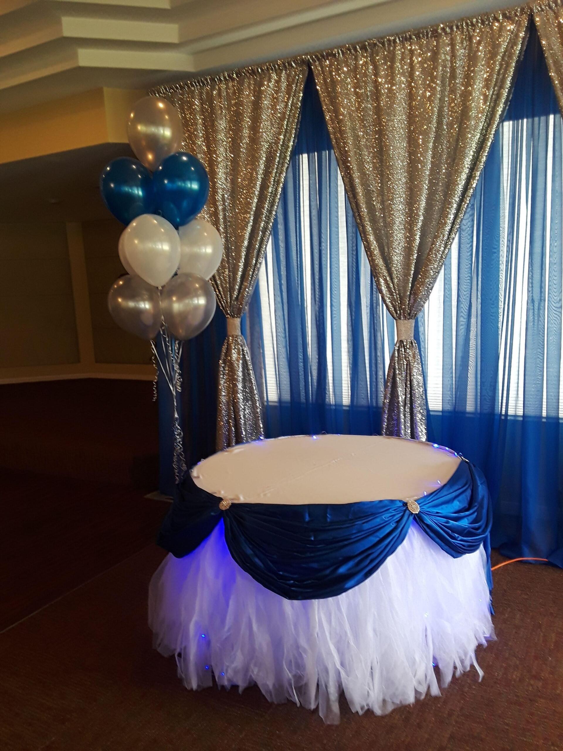 A table with blue and white decorations and balloons