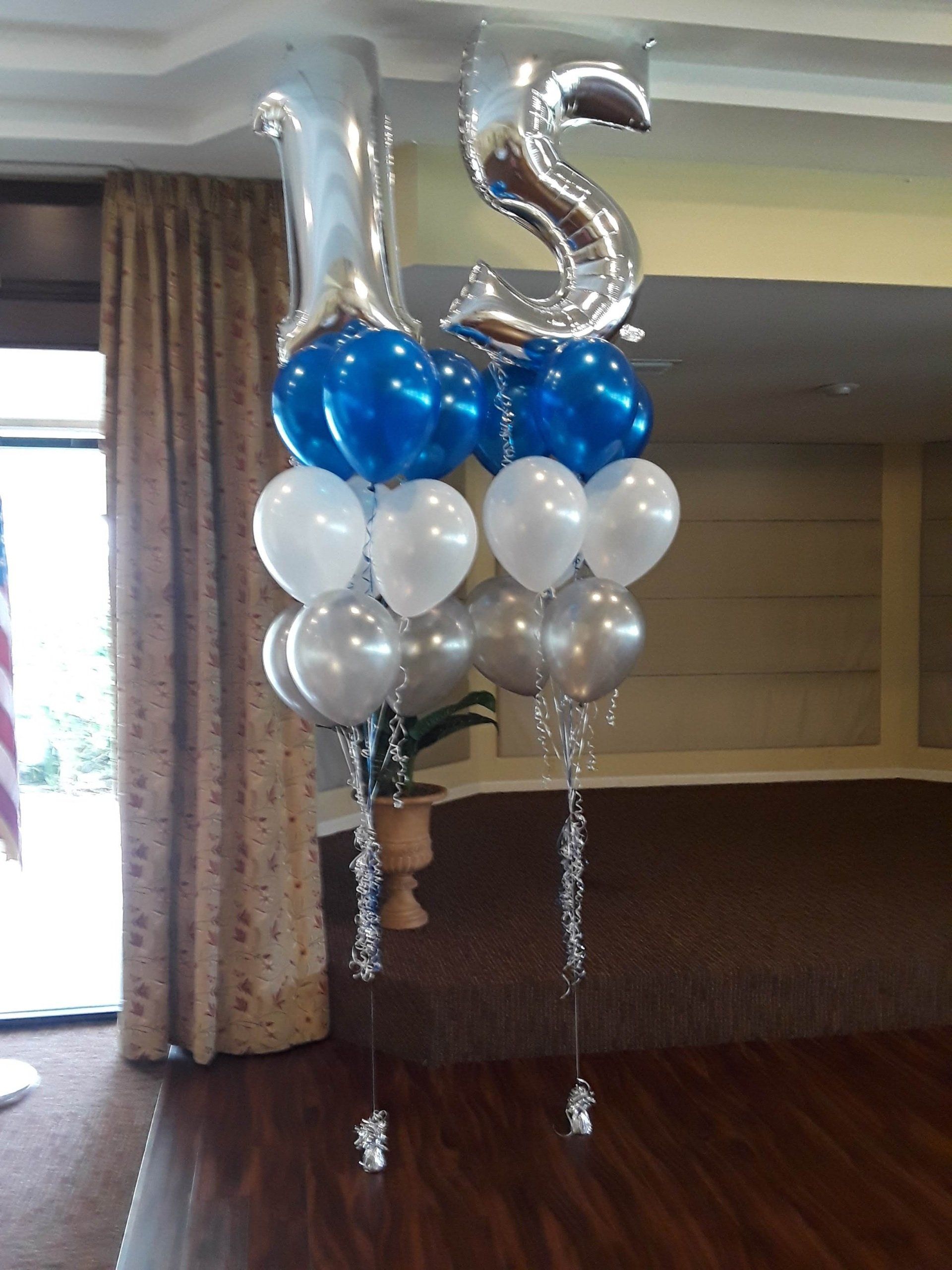A bunch of balloons are hanging from the ceiling in a room.