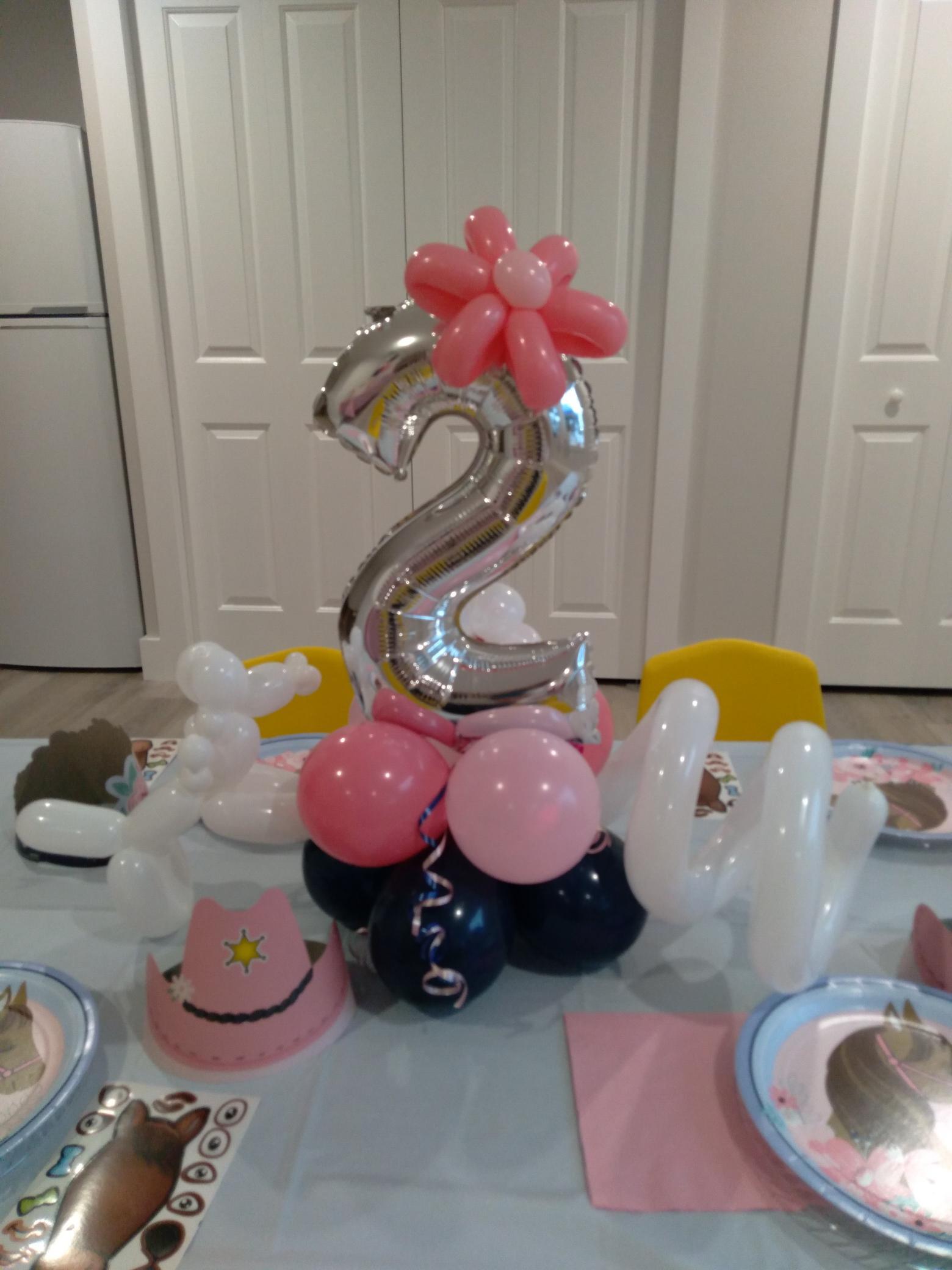 A table topped with balloons and a number two balloon.