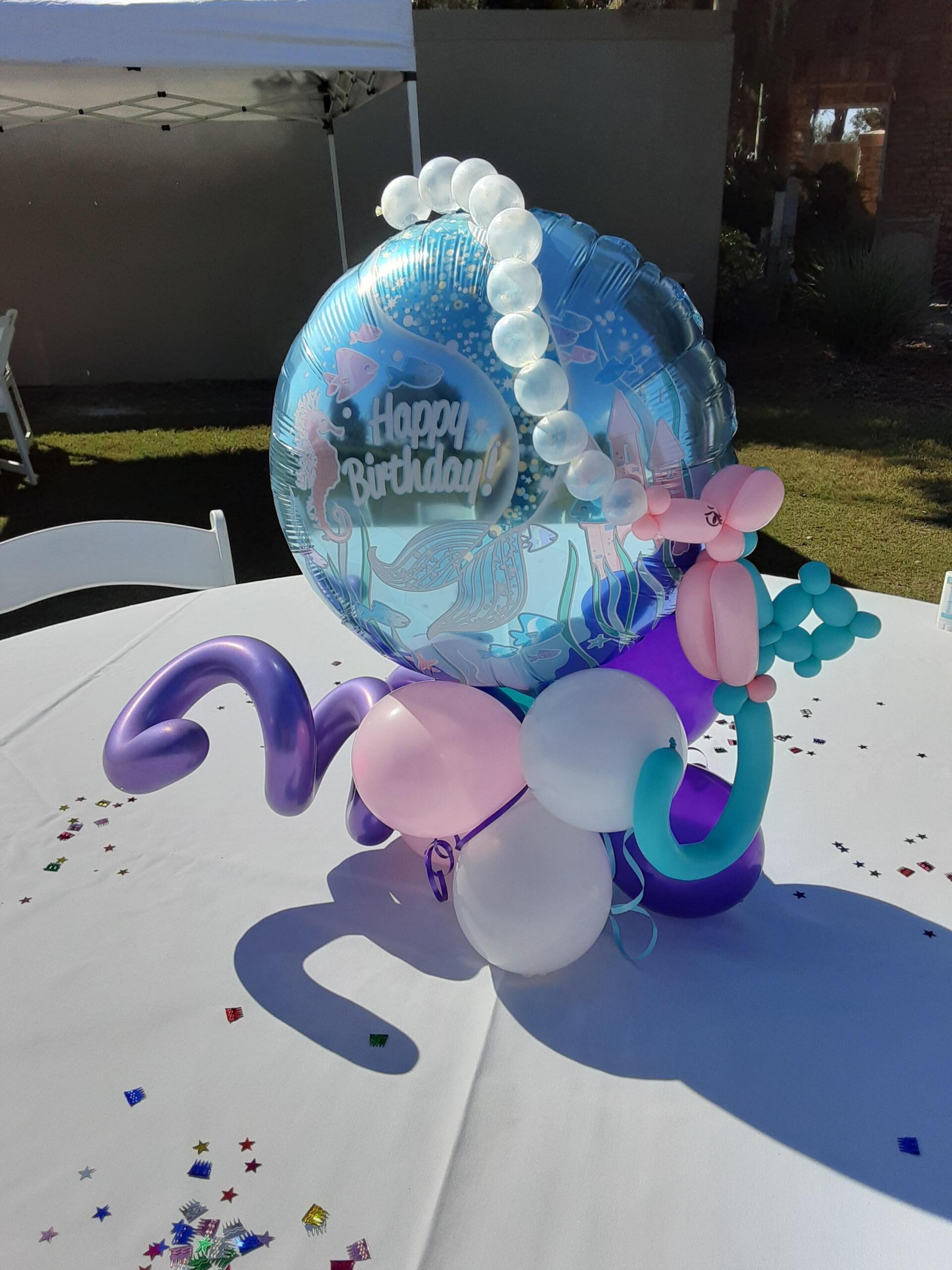A table with balloons and a balloon that says happy birthday
