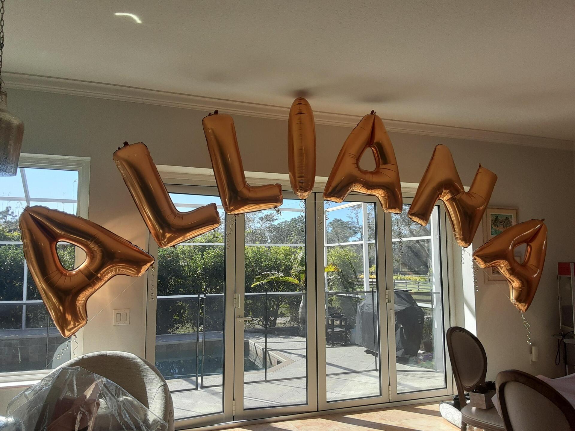 A room with balloons that spell out the name allan