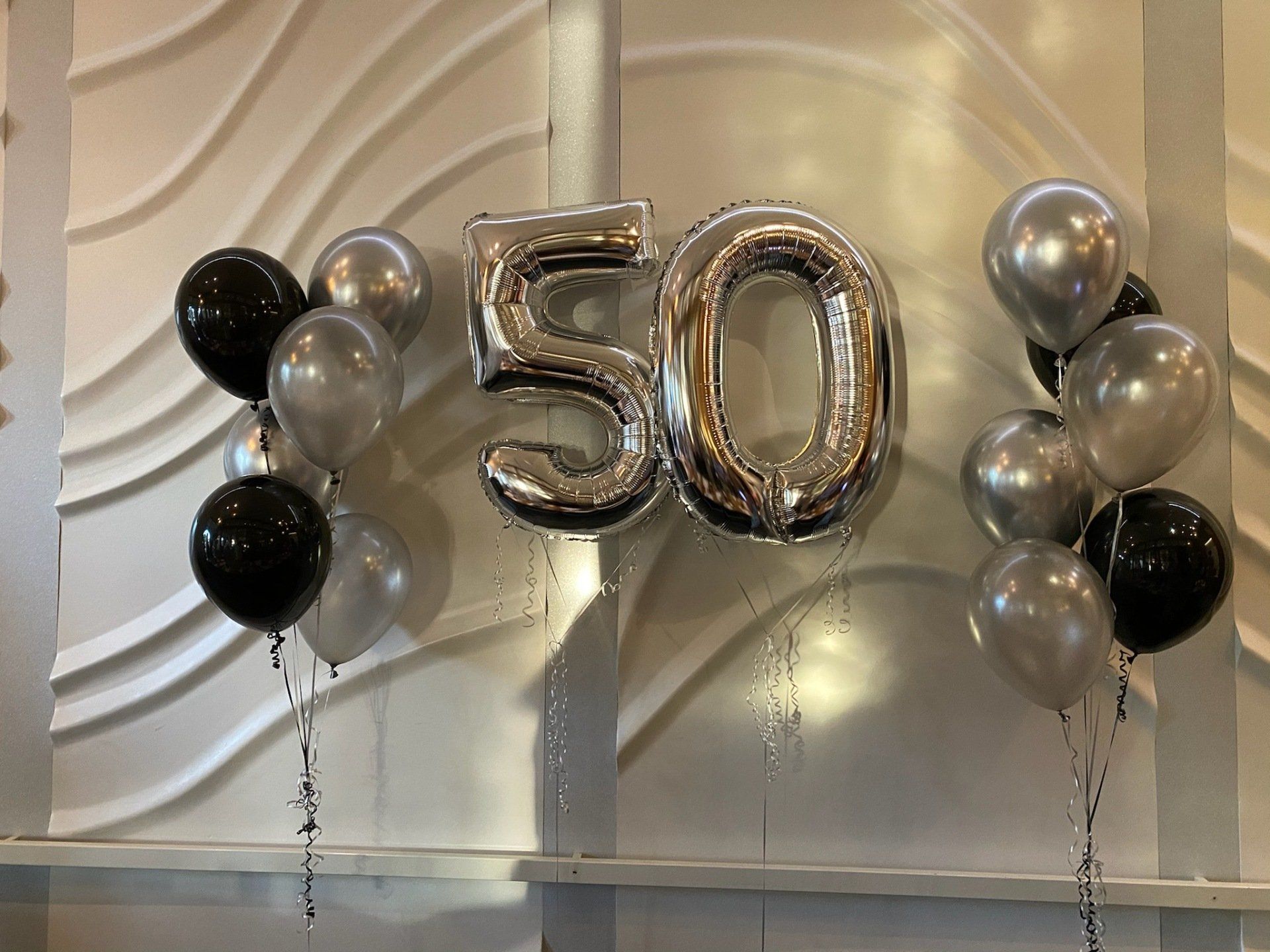 A bunch of balloons with the number 50 on them