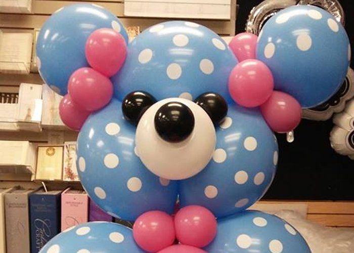 A teddy bear made out of blue and pink polka dot balloons