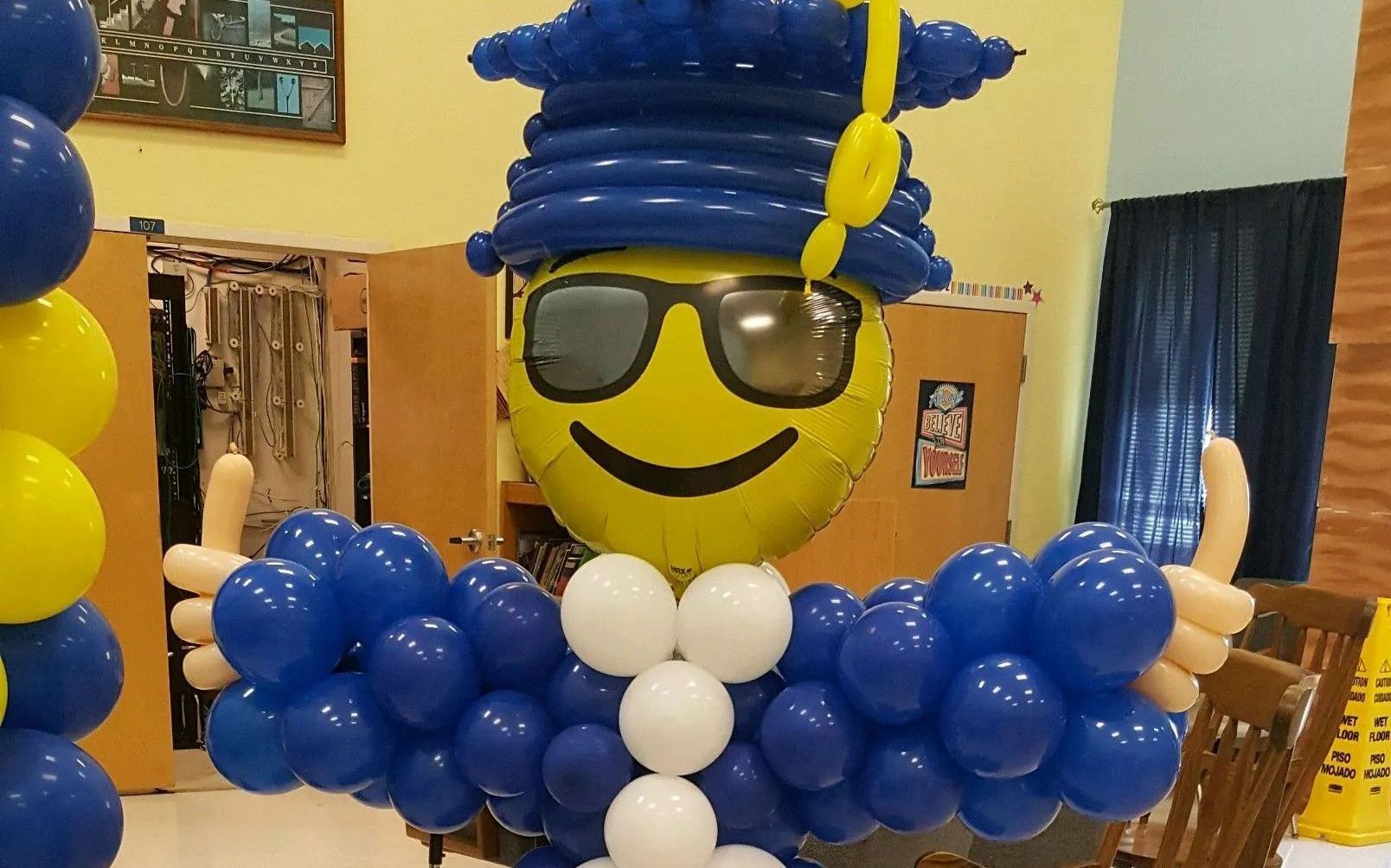 A balloon sculpture of a man wearing a graduation cap and gown