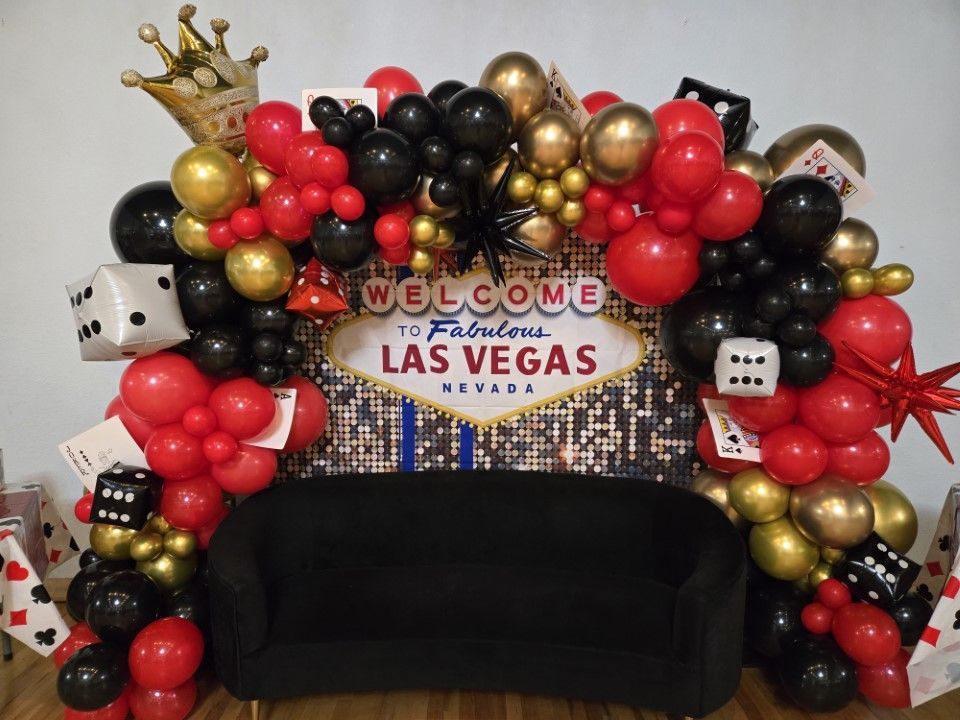 A couch is surrounded by balloons and a sign that says welcome to las vegas.