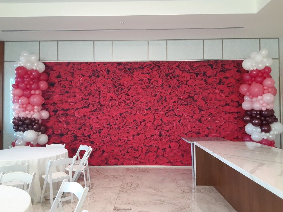 A room with tables and chairs and balloons on the wall