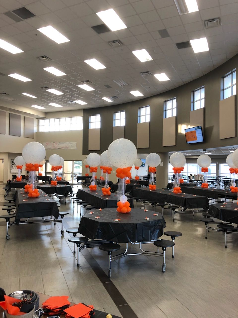 A large room with tables and chairs decorated with balloons