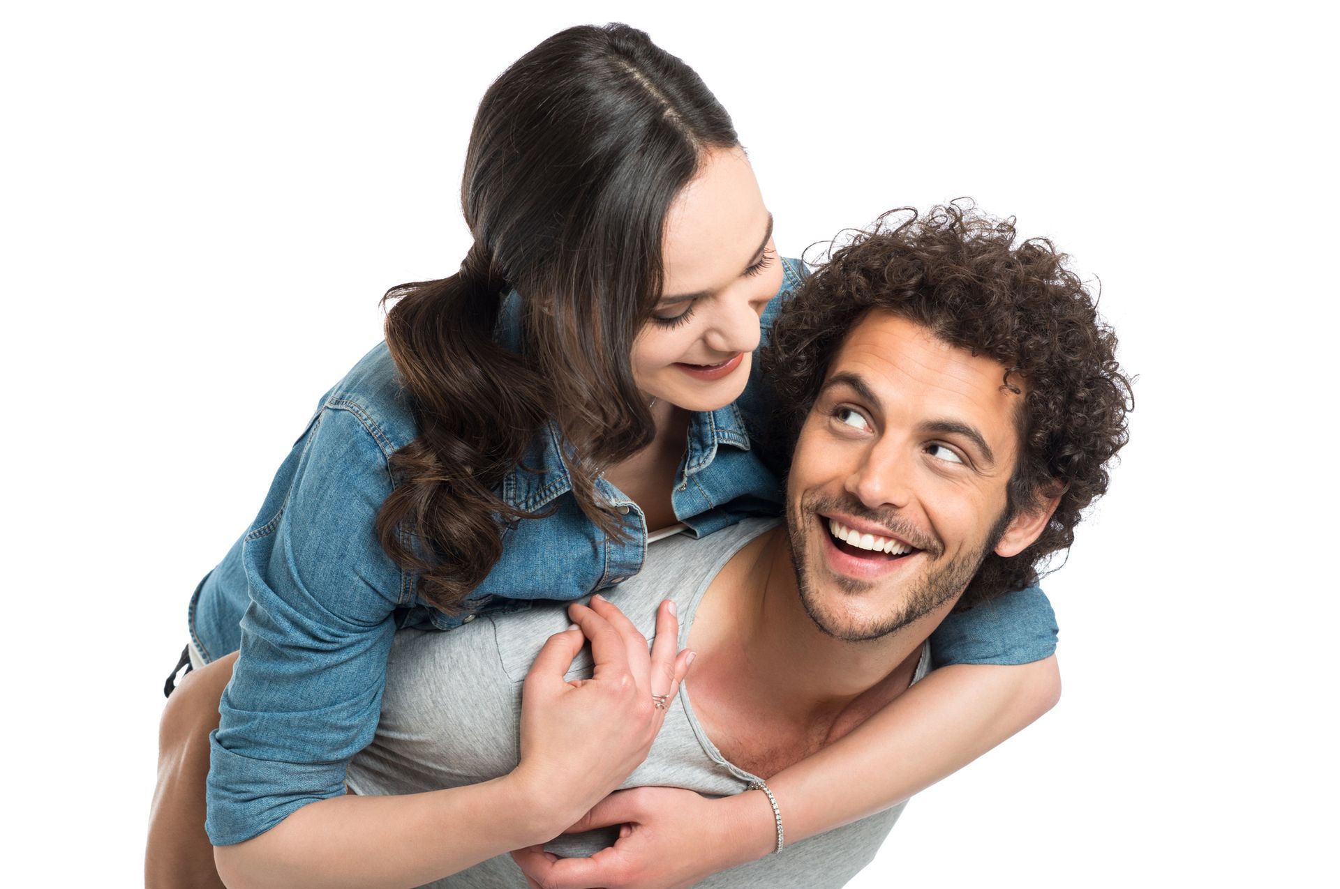 A man gives a piggyback ride to a woman. 