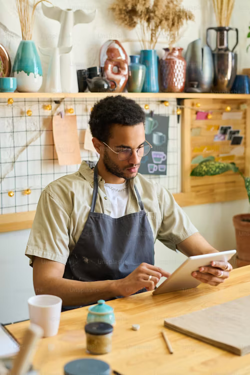 A man looks at his tablet in his workplace. 