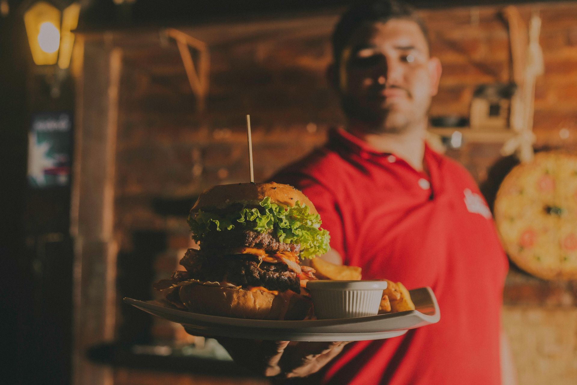 A man serves a burger at a restaurant.