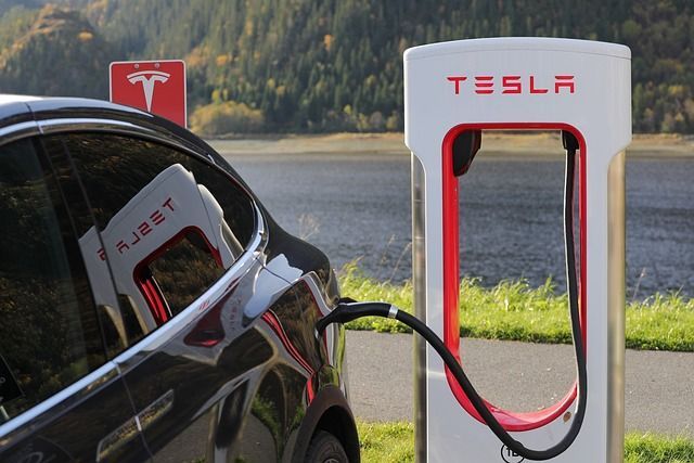 A Tesla car charges its battery at a charging station.