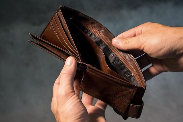  A man holds open an empty wallet in his hands. 