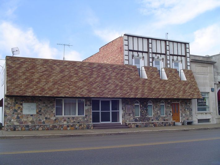 A brick building with a roof that has a few windows on it