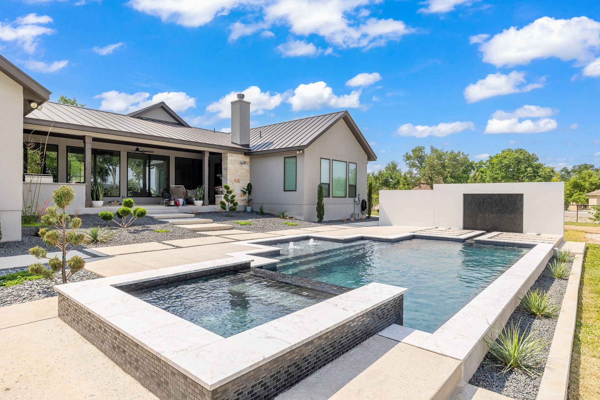 Luxurious home with a pool. Modern design, light blue pool, gray accents, sunny day.