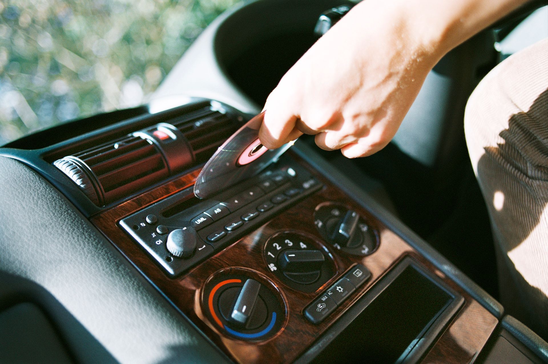 Hand turning a car stereo knob on the dashboard