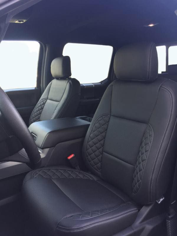 Black leather car seats with diamond-stitched accents in the front cabin of a vehicle.