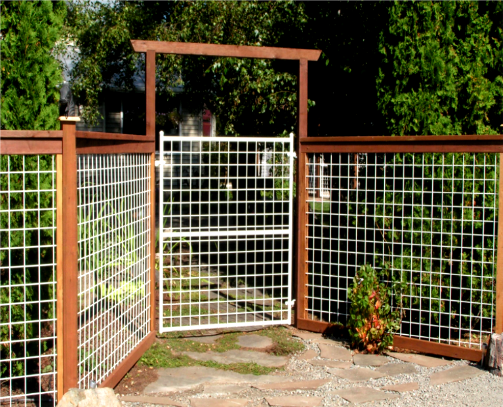 White wire gate and fence with wooden posts, leading to a garden.